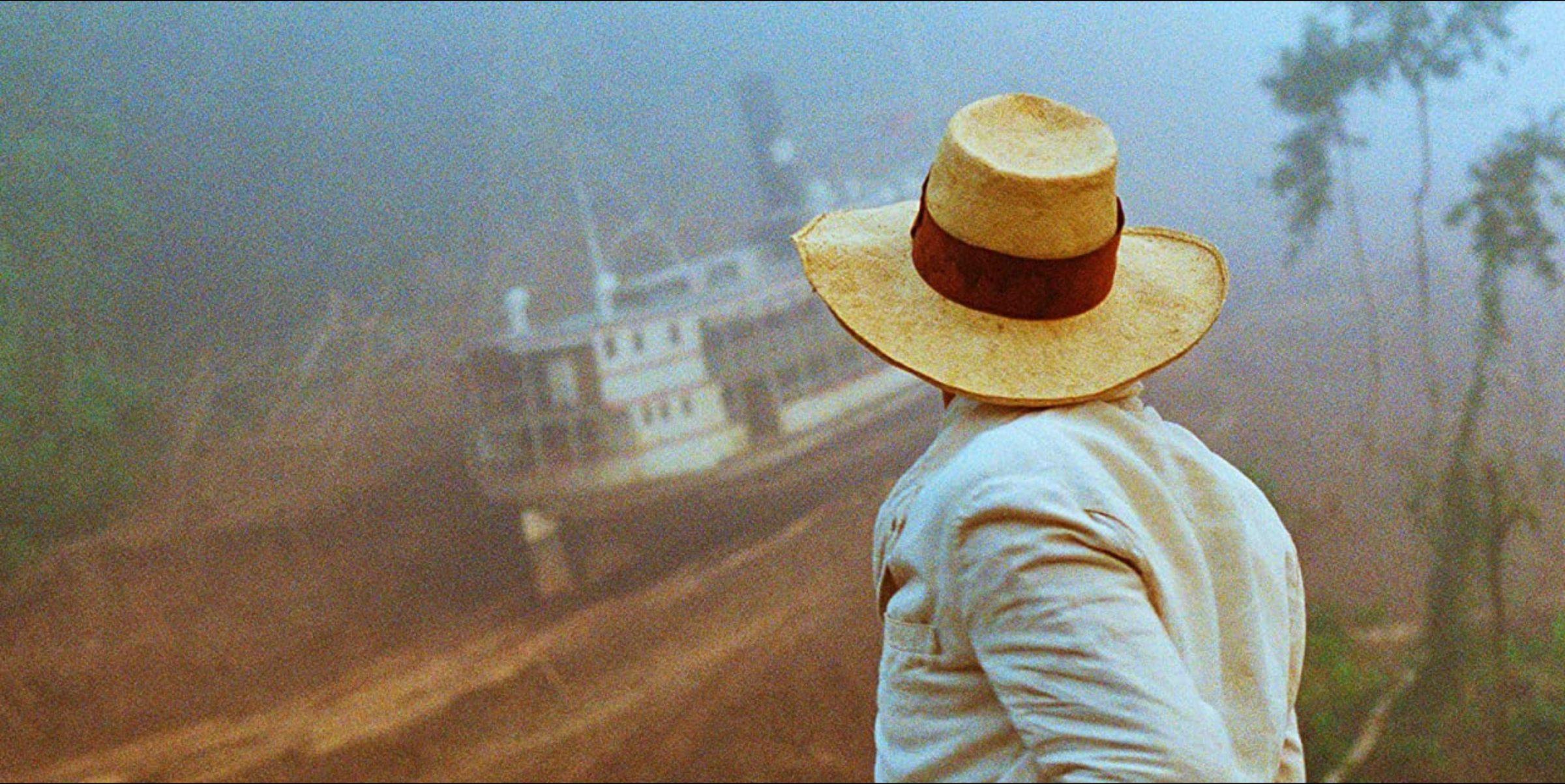 Production still of the film Fitzcarraldo by Werner Herzog. A man watch a huge boat being dragged up a mountain.